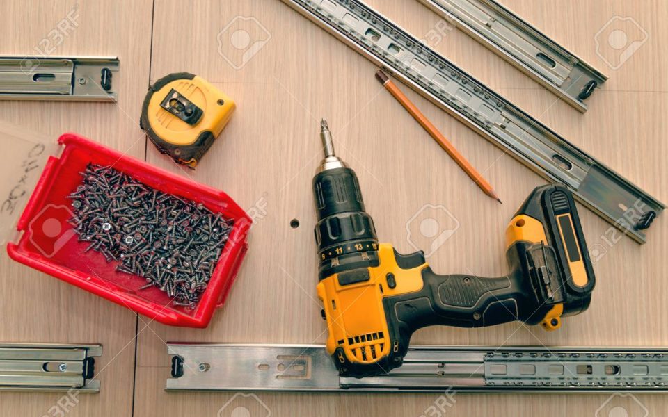 Assembling of furniture closeup Assembling furniture from chipboard, using a cordless screwdriver, close up.